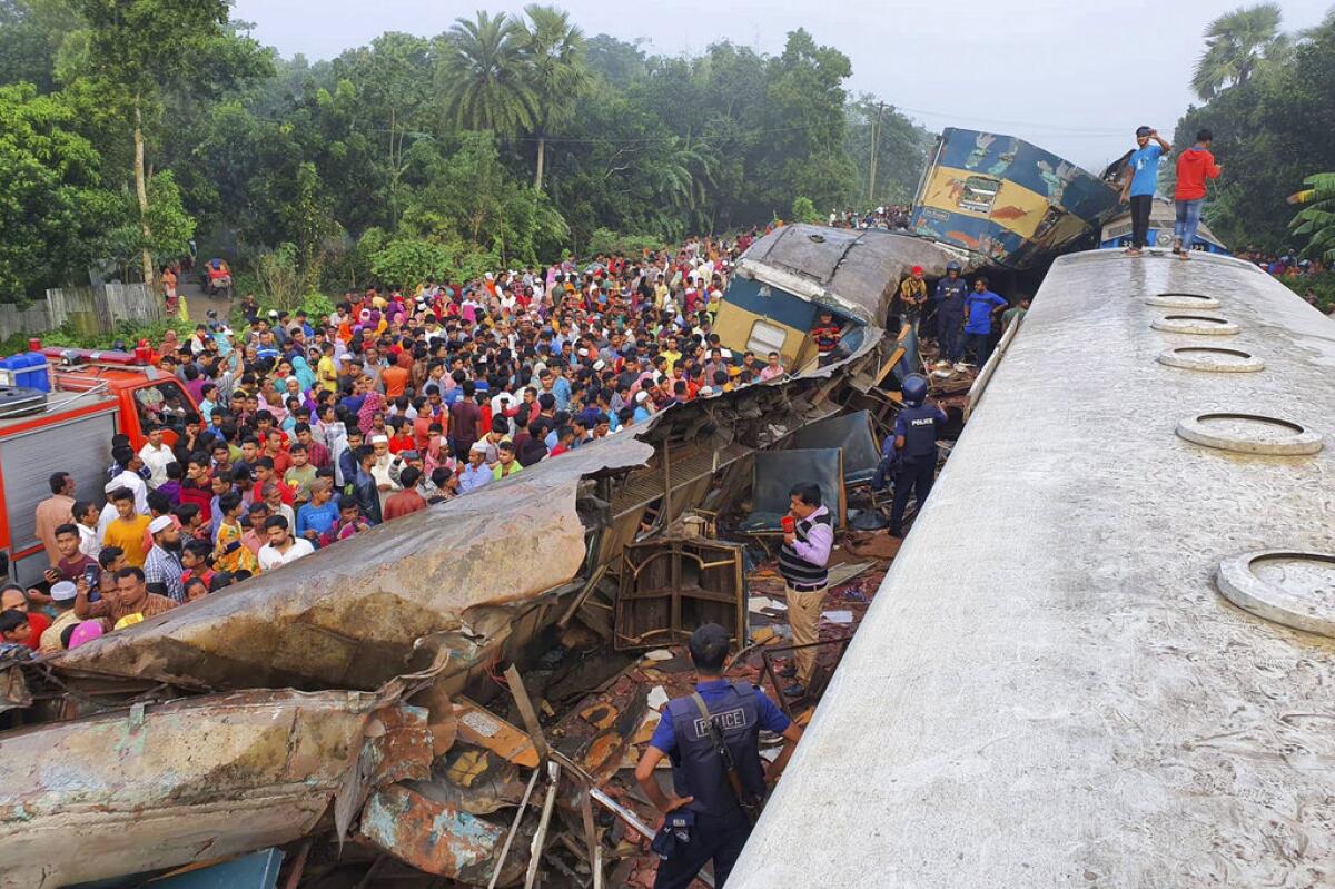People gather near the wreckage of two trains that collided Nov. 12 in eastern Bangladesh, 51 miles east of the capital of Dhaka.