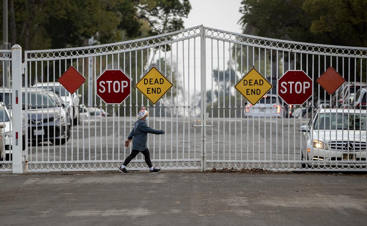 A pedestrian walks along Gramercy Place inside the locked gates on Pico Boulevard in L.A.'s Country Club Park neighborhood.