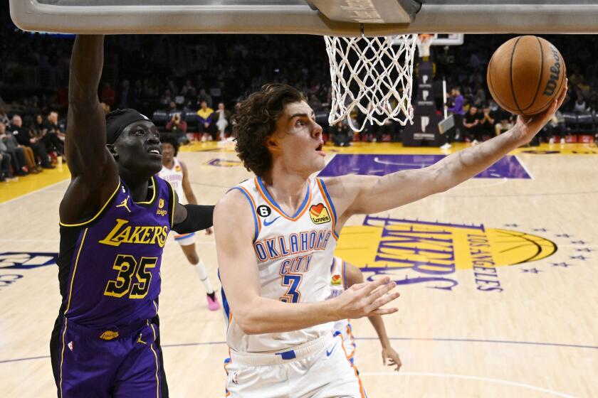 Oklahoma City Thunder guard Josh Giddey, right, shoots as Los Angeles Lakers forward Wenyen Gabriel defends during the first half of an NBA basketball game Friday, March 24, 2023, in Los Angeles. (AP Photo/Mark J. Terrill)