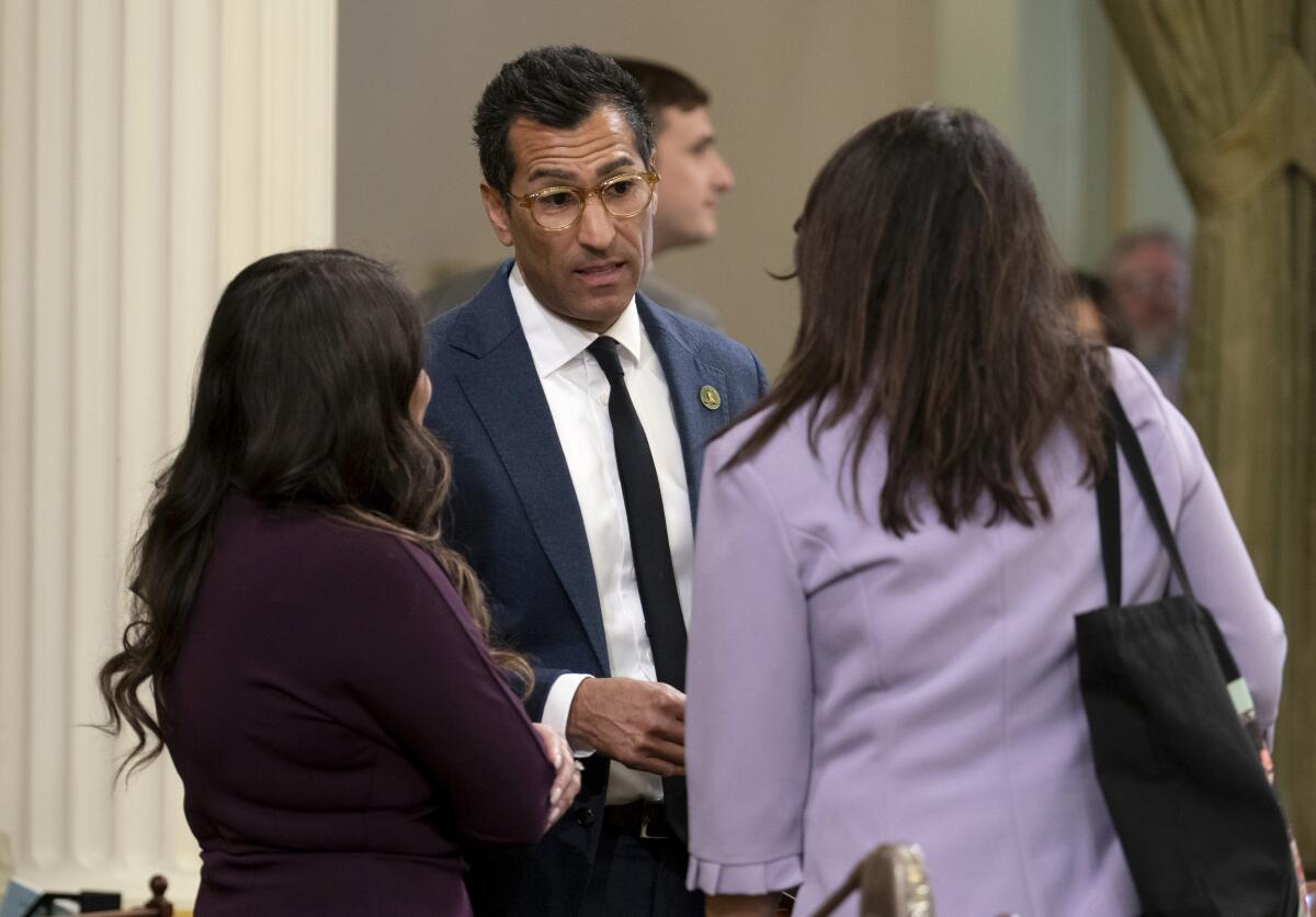 California Assembly Speaker Robert Rivas of Hollister, center, talks with two Assembly members.