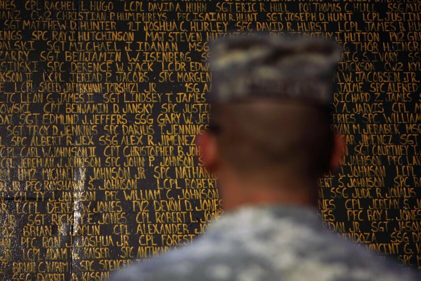 A soldier stands in front of a monument bearing the names of U.S. service members killed in Iraq since the 2003 U.S. invasion, at Forward Operating Base Warrior in Kirkuk in 2010.