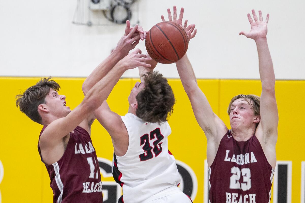 Laguna Beach's Lucas Kravitz, left, and Brooks Hogenauer, right, block a shot by San Clemente's Berk Harris in the Grizzly Invitational on Thursday at Godinez High.