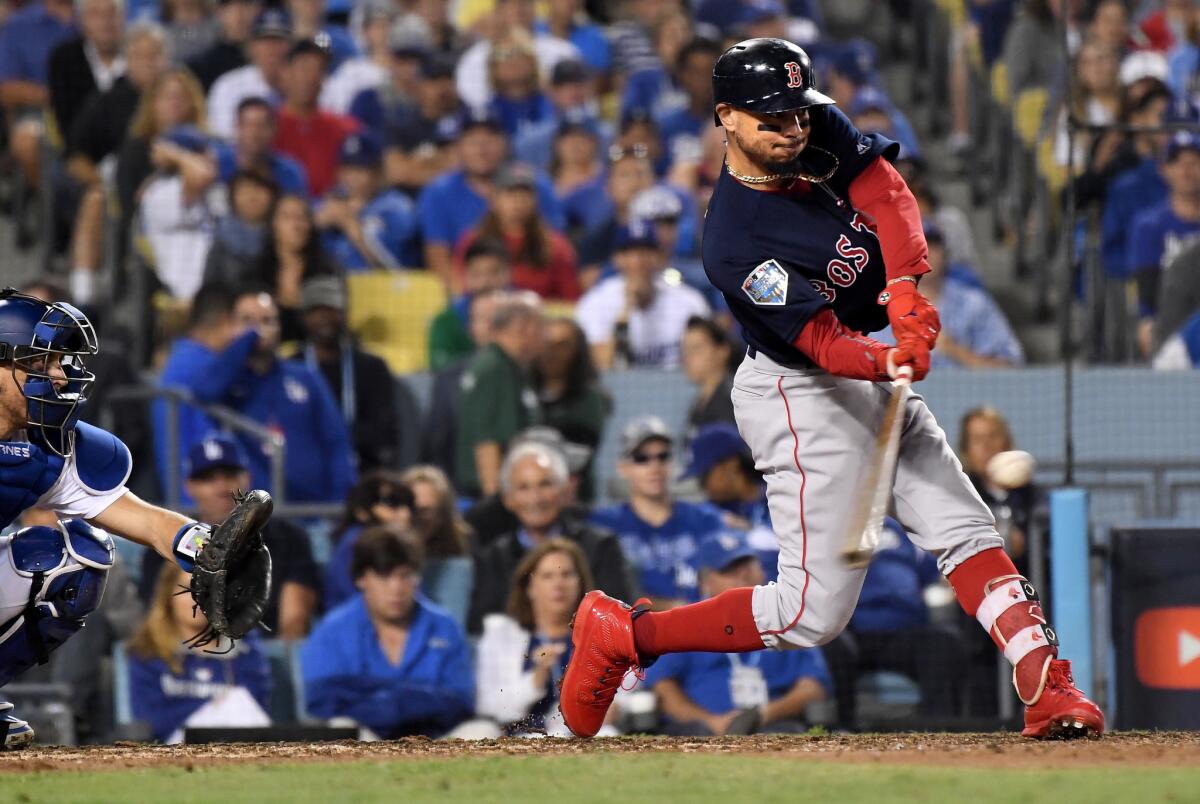 Then-Red Sox center fielder Mookie Betts connects for a solo home run off Dodgers pitcher Clayton Kershaw.