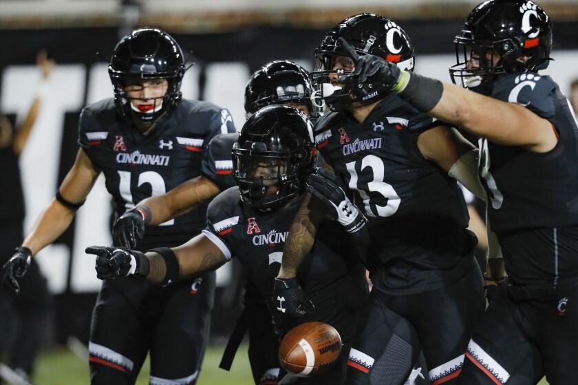 CORRECTS TO CINCINNATI WIDE RECEIVER TRENT CLOUD, INSTEAD OF UCF WIDE RECEIVER GABRIEL DAVIS - Cincinnati wide receiver Trent Cloud 13) celebrates his touchdown with teammates in the first half of an NCAA college football game against UCF on Friday, Oct. 4, 2019, in Cincinnati. (AP Photo/John Minchillo)