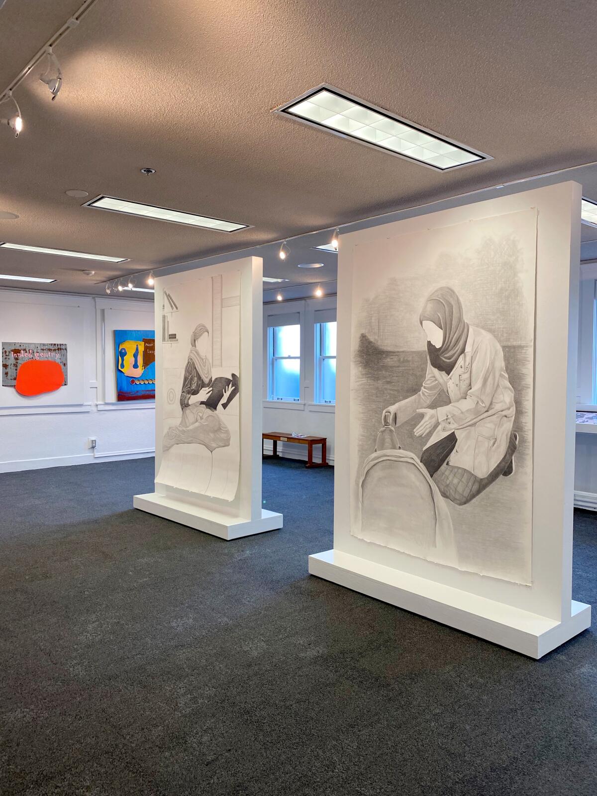 At the center, drawings by Yara Almouradi and in the background paintings by Matt Key 