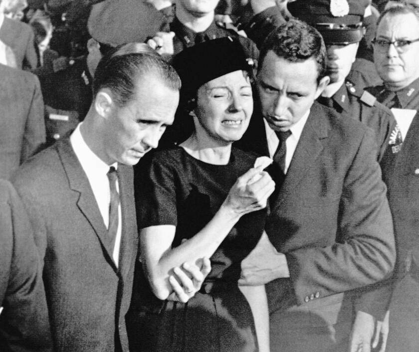 FILE - In this Monday, Nov. 25, 1963, file photo, Marie Tippit, widow of police officer J.D. Tippit who was slain during the search for President John F. Kennedy's assassin, is led weeping from Beckley Hills Baptist Church in Dallas after funeral services for her husband. Tippit who was a 35-year-old mother of three when her husband, Officer J.D. Tippit, was killed on Nov. 22, 1963, has died at age 92. Her son said she died Tuesday, March 2, 2021, at a hospital in the East Texas city of Sulphur Springs after being diagnosed with pneumonia following a positive test for COVID-19. (AP Photo, File)