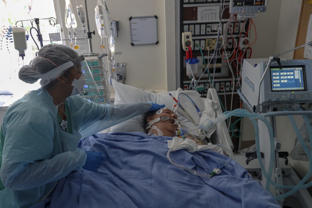Nurse Kyah Paschall checks on coronavirus patient Patricia Luera at Paradise Valley Hospital in National City.