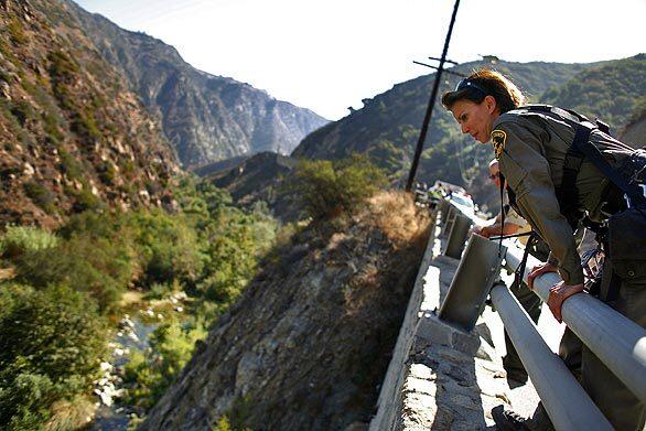 A Los Angeles County sheriff's deputy looks over a guard rail along Malibu Canyon Road during the search for Mitrice Richardson, 24, who disappeared after being released from a sheriff's substation in the predawn hours of Sept. 17.