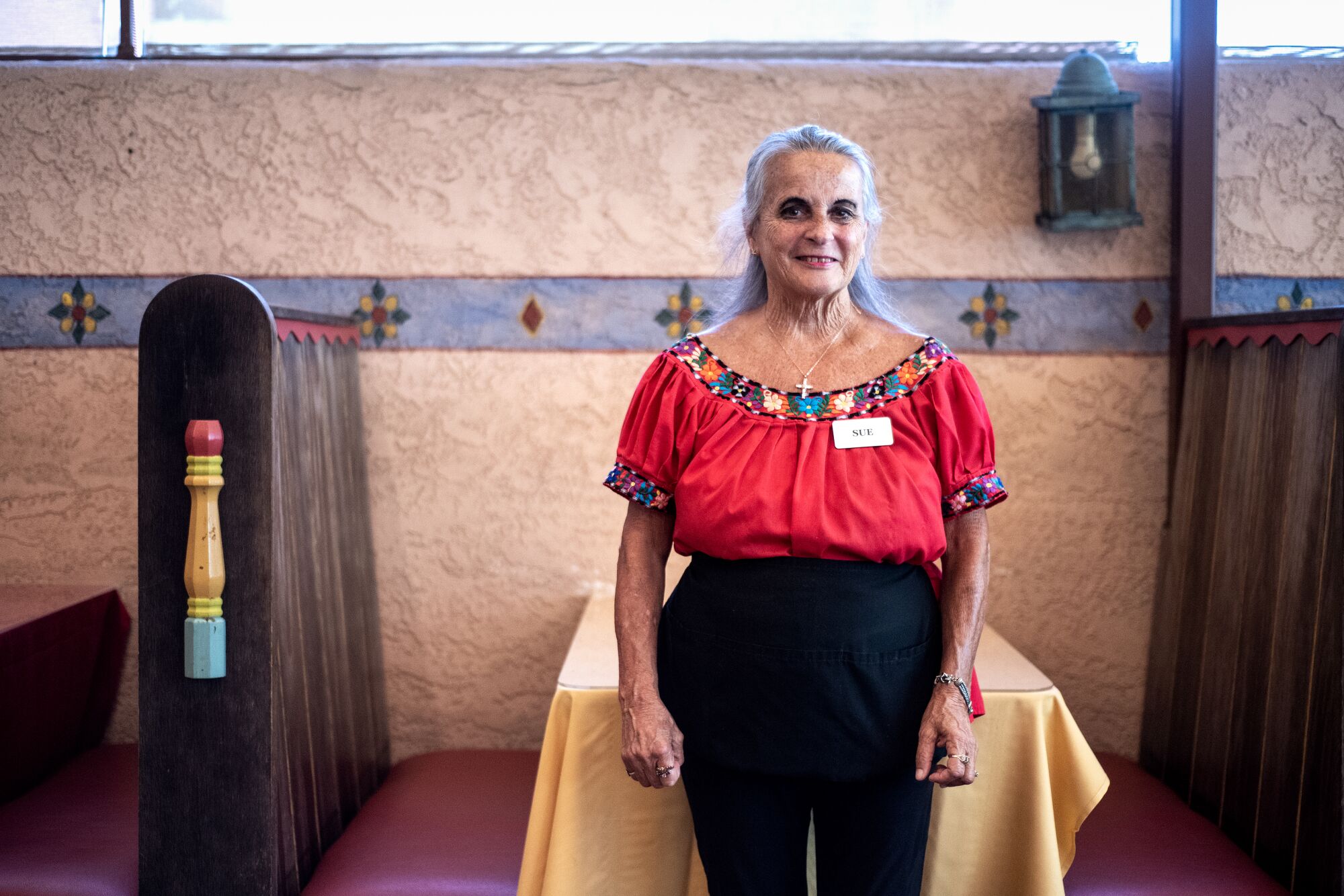 Sue Killian standing in front of a table stand at El Cholo restaurant.