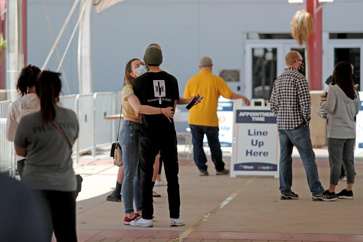 A couple waits in line at the new COVID-19 vaccination super POD site at the Orange County fairgrounds.
