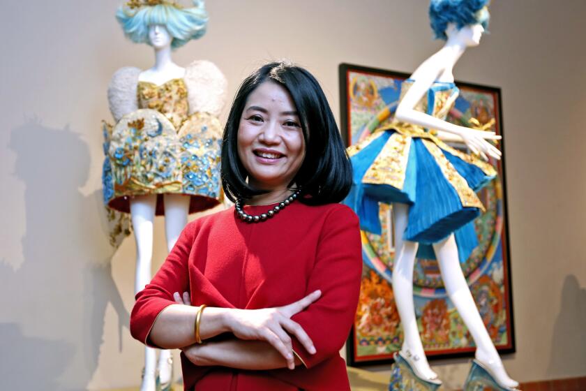 World-renowned couture designer Guo Pei stands in front of some of her "Garden of Soul" pieces in the West Coast premiere of "Guo Pei: Couture Beyond" at Bowers Museum in Santa Ana.
