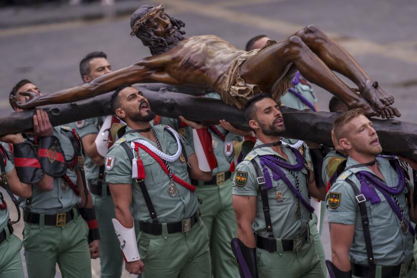 Members of the Spanish Legion, an elite unit of the Spanish Army, hold up the El Cristo de la Buena Muerte, or Christ of the Good Death, during a ceremony ahead of the procession in Malaga, Southern Spain, southern Spain, Thursday, March 28, 2024. Hundreds of processions will take place throughout Spain during the Easter Holy Week. (AP Photo/Manu Fernandez)