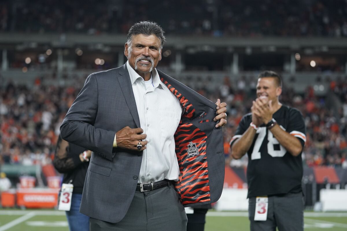 FILE -Former Cincinnati Bengals' Anthony Munoz holds open his jacket during a "Ring of Honor" ceremony during an NFL football game between the Cincinnati Bengals and the Jacksonville Jaguars, Thursday, Sept. 30, 2021, in Cincinnati. The Pro Football Hall of Fame has hired Anthony Muñoz as its first Chief Football Relationship Officer. The hall said Thursday, May 12, 2022 that the 1998 inductee will engage with current and prospective business partners and sponsors; be involved in philanthropic efforts for the museum; promoting the hall's mission and initiatives.(AP Photo/Michael Conroy, File)