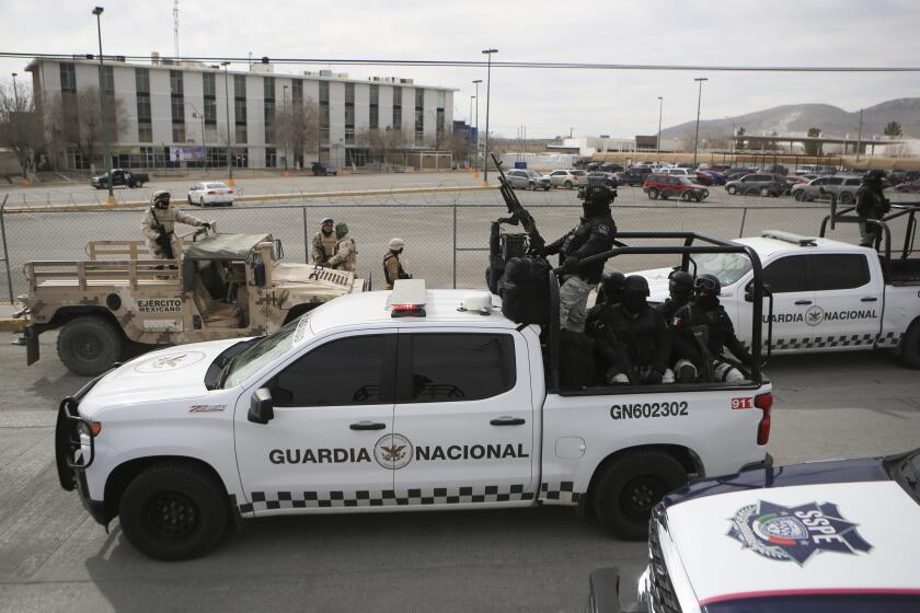 Mexican National Guard stand guard outside a state prison in Ciudad Juarez, Mexico, Sunday Jan 1, 2023. Mexican soldiers and state police regained control of a state prison in Ciudad Juarez across the border from El Paso, Texas after violence broke out early Sunday, according to state officials. (AP Photo/Christian Chavez)