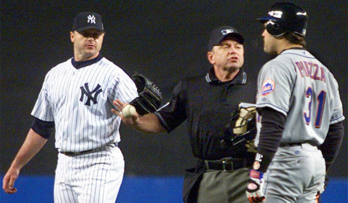 Home plate umpire Charlie Reliford steps between New York Mets' Mike Piazza (31) and New York Yankees pitcher Roger Clemens after Clemens threw a part of Piazza's bat back at him during Game 2 of the 2000 World Series.