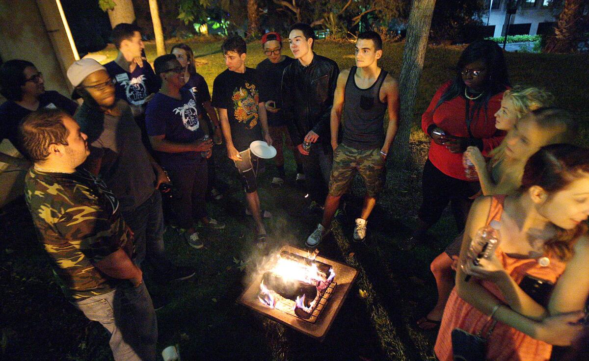 Students circle around a small fire at Woodbury University.