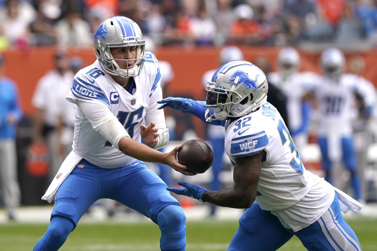 Detroit Lions quarterback Jared Goff hands off to running back D'Andre Swift.