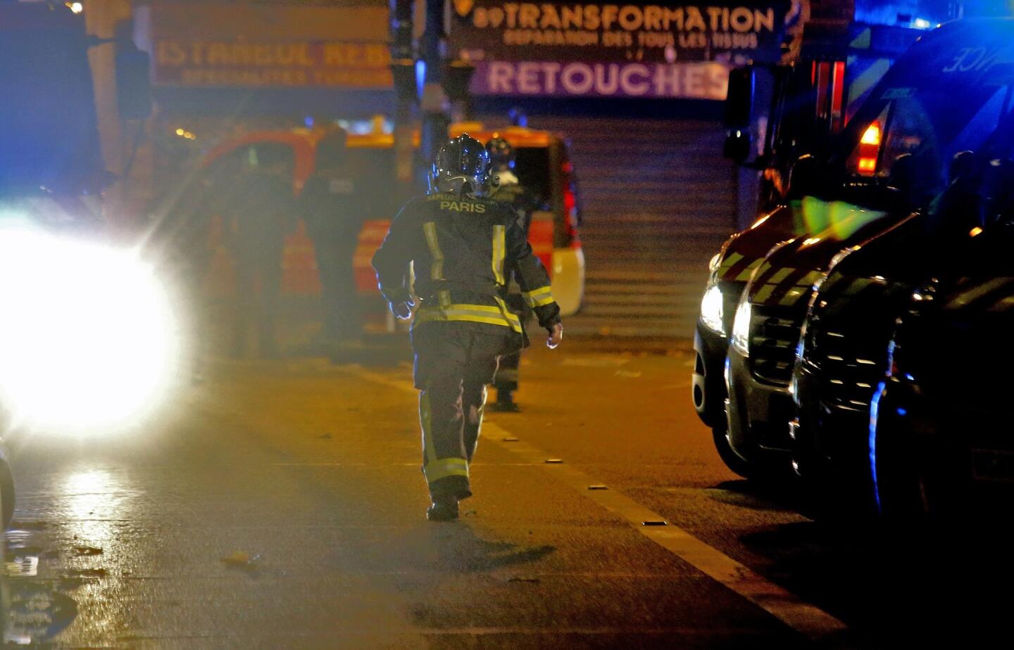 A rescue worker runs after an explosion in the 10th district of Paris, Friday, Nov. 13, 2015. Several dozen people were killed Friday in a series of terror attacks, the deadliest to hit Paris since World War II, French President Francois Hollande said, announcing that he was closing the country's borders and declaring a state of emergency. (AP Photo/Jacques Brinon)