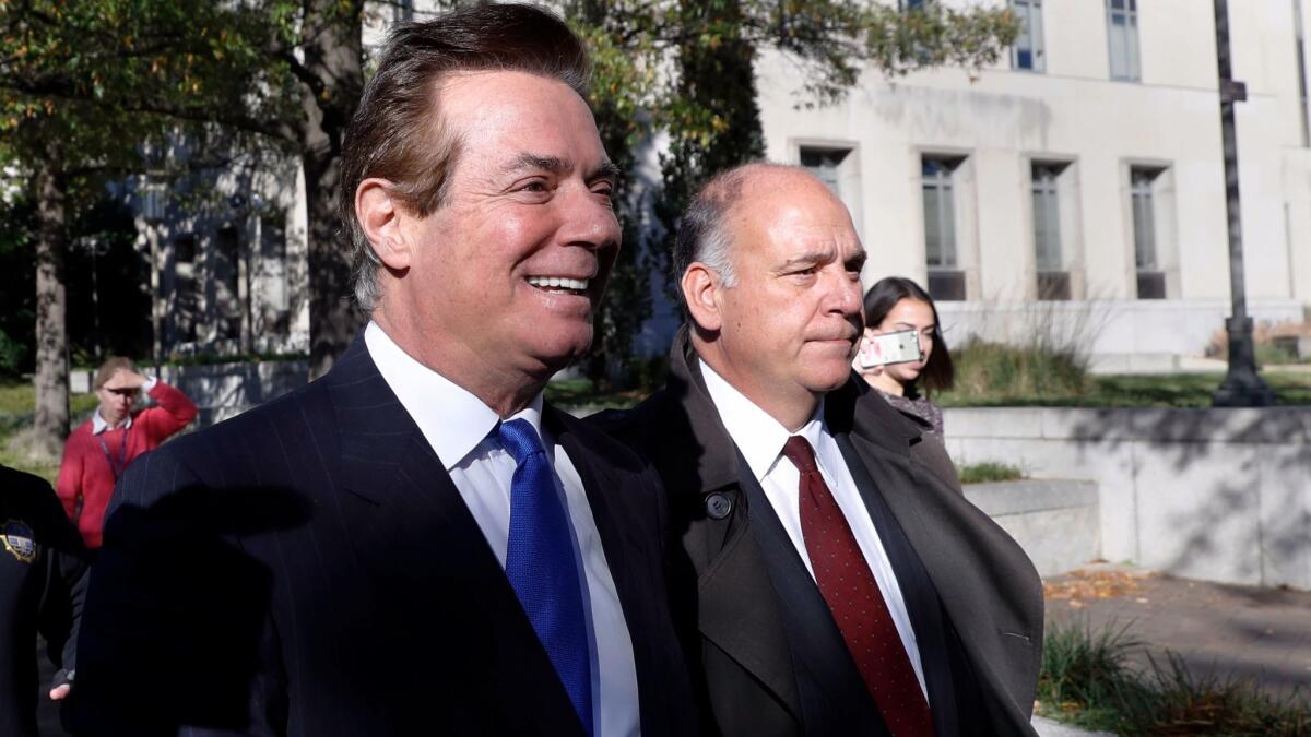 Former Trump campaign manager Paul Manafort, left, leaves Federal District Court in Washington on Oct. 30.