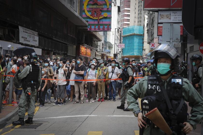 Police placed a perimeter line to control the movements of protesters in Causeway Bay before the annual handover march in Hong Kong, Wednesday, July. 1, 2020. Hong Kong marked the 23rd anniversary of its handover to China in 1997, and just one day after China enacted a national security law that cracks down on protests in the territory. (AP Photo/Kin Cheung)