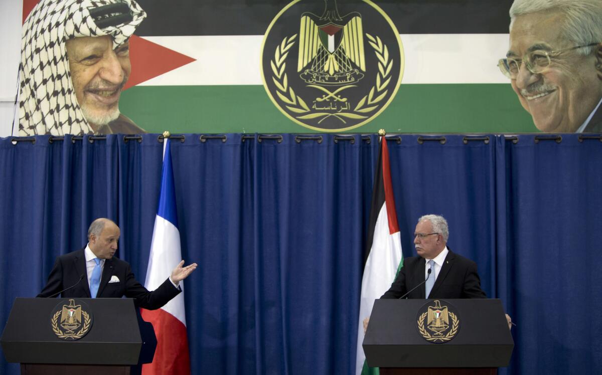 French Foreign Minister Laurent Fabius, left, speaks Sunday during a press conference with Palestinian Foreign Minister Riyad Maliki in the West Bank city of Ramallah.