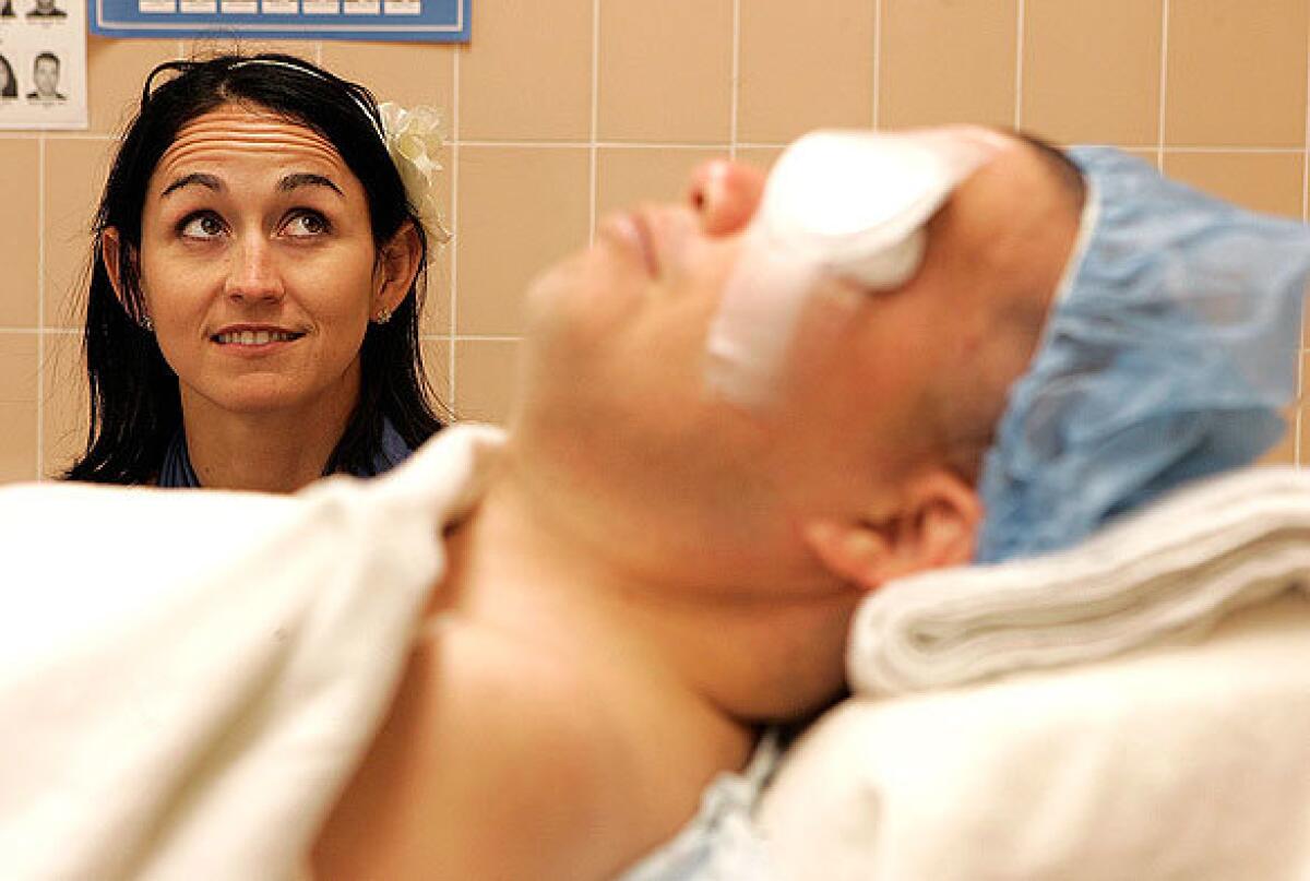 Beth Fong watches the monitors as her husband, Lawrence Fong, recovers from a surgery at the Jules Stein Eye Institute at UCLA. Lawrence Fong , a sports chiropractor , triathlete and iron-man competitor, slipped and fell in a restaurant bathroom last year and became comatose. Doctors told Beth Fong that he was brain-dead.