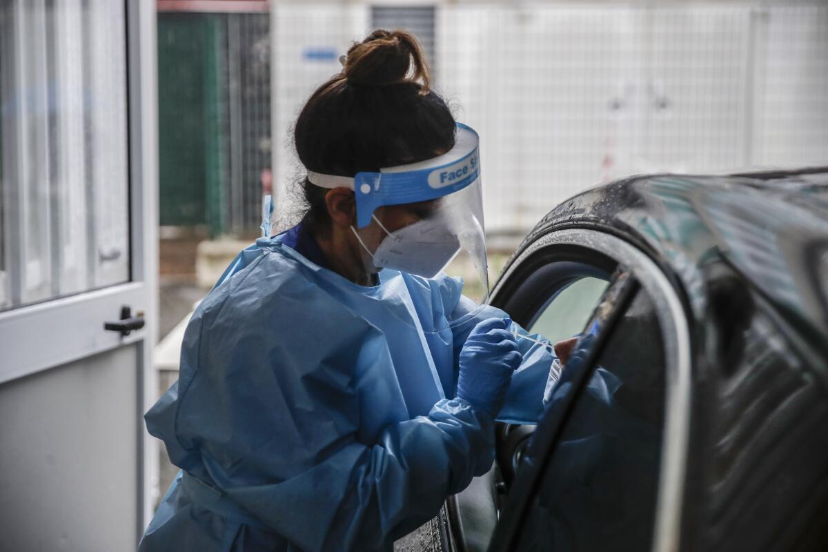 A paramedic takes swabs for a coronavirus test from a motorist in Milan, Italy, on Thursday.