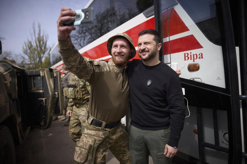 In this photo provided by the Ukrainian Presidential Press Office, Ukrainian president Volodymyr Zelenskyy poses for a selfie with a soldier at a position in Avdiivka, Donetsk region, Ukraine, Tuesday, April 18, 2023. (Ukrainian Presidential Press Office via AP)