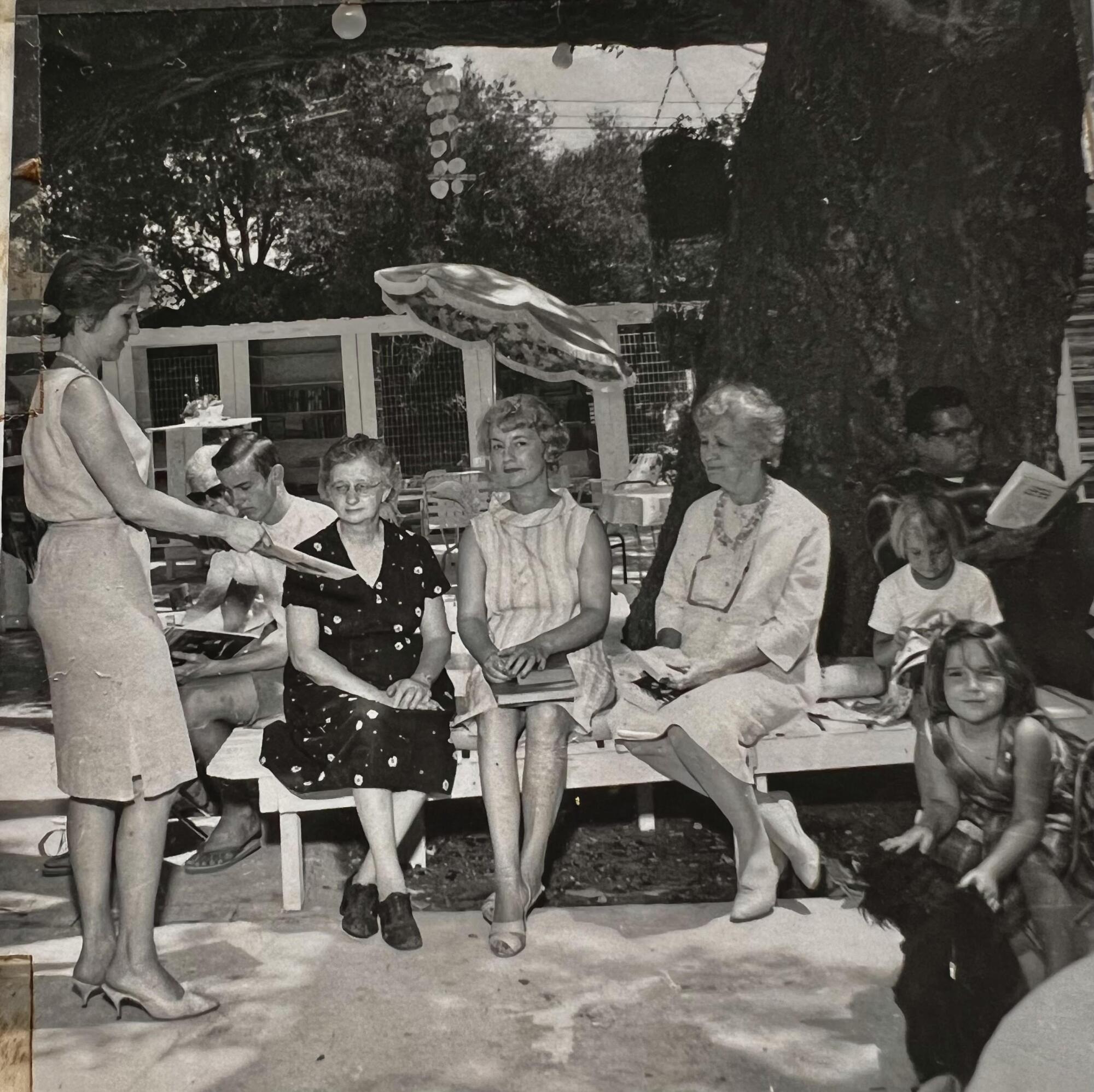 A black-and-white photo of a group of customers participating in a book club.