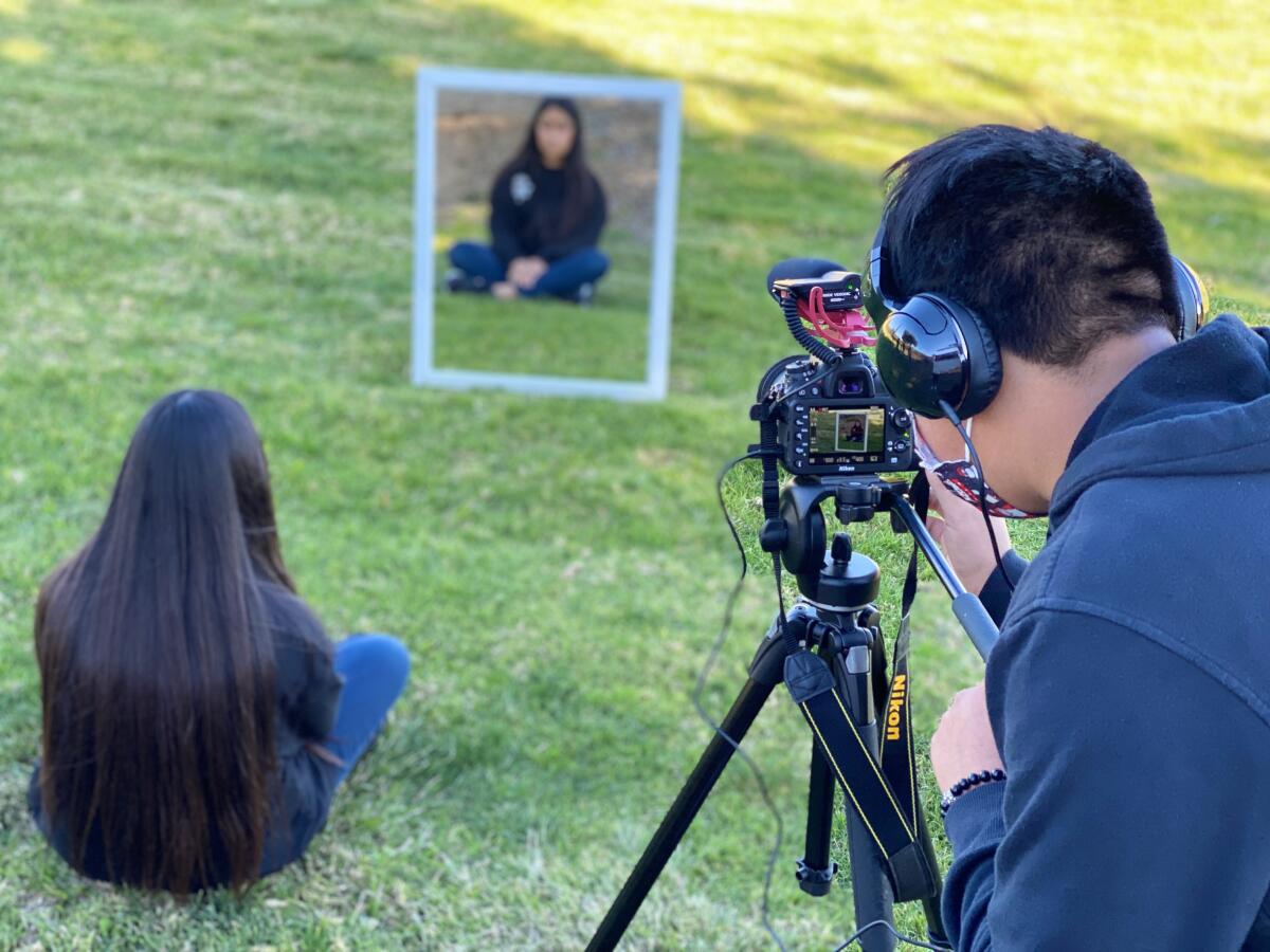 El videógrafo estudiantil Jesús Aquino, a la derecha, filma a Natalie López 