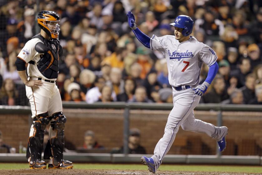 Dodgers infielder Alex Guerrero celebrates as he runs past Giants catcher Buster Posey after hitting a pinch hit, two-run home run to tie the game.