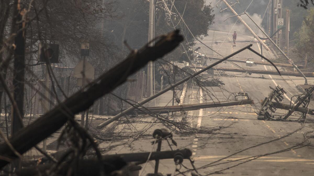 Downed power poles and lines block a street in Hidden Valley.