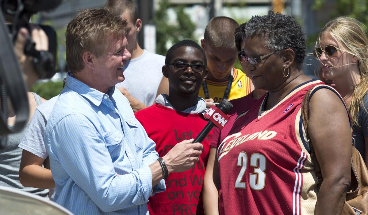 A Cleveland Cavaliers fan talks with a reporter from CNN outside Quicken Loans Arena on Friday following LeBron James' announcement that he would return to the Cavaliers.