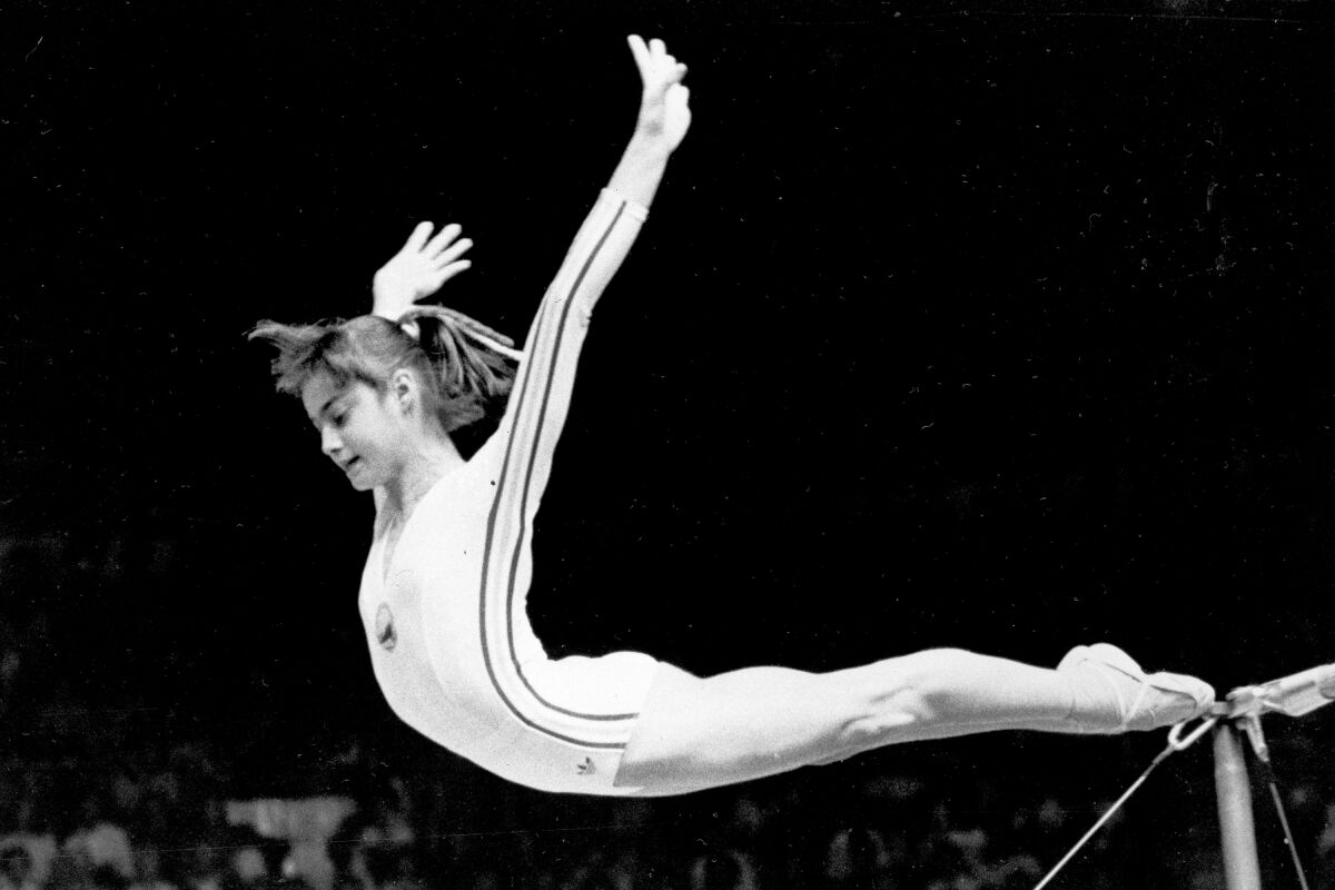 FILE - In this July 18, 1976, file photo, Romania's Nadia Comaneci dismounts from the uneven parallel bars to score a perfect 10.00 in the women's gymnastics competition at the Summer Olympic Games in Montreal. (AP Photo/Suzanne Vlamis, File)