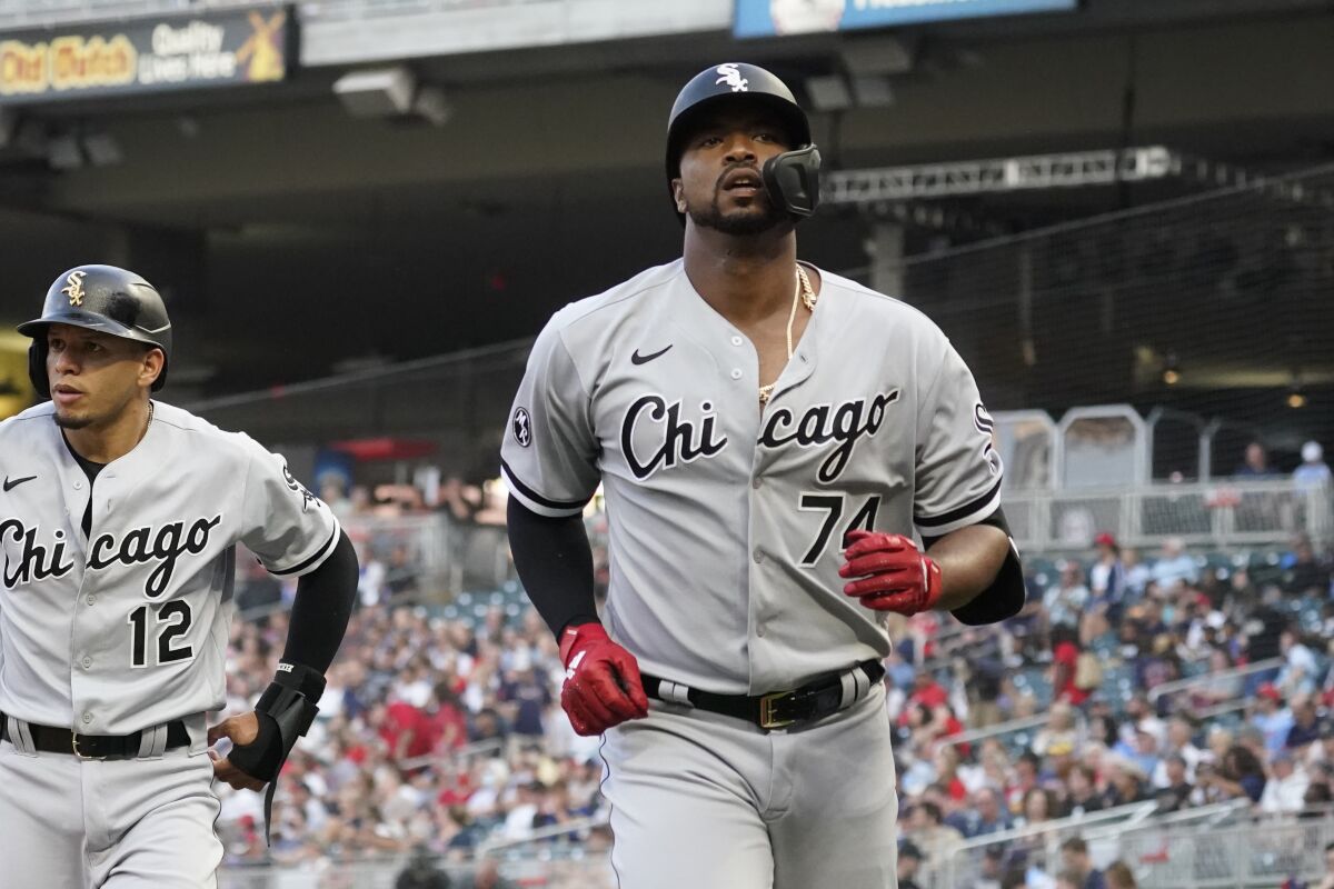 Chicago White Sox's Eloy Jimenez (74) scores on his two-run home run off Minnesota Twins pitcher Beau Burrows in the first inning of a baseball game, Monday, Aug. 9, 2021, in Minneapolis. (AP Photo/Jim Mone)