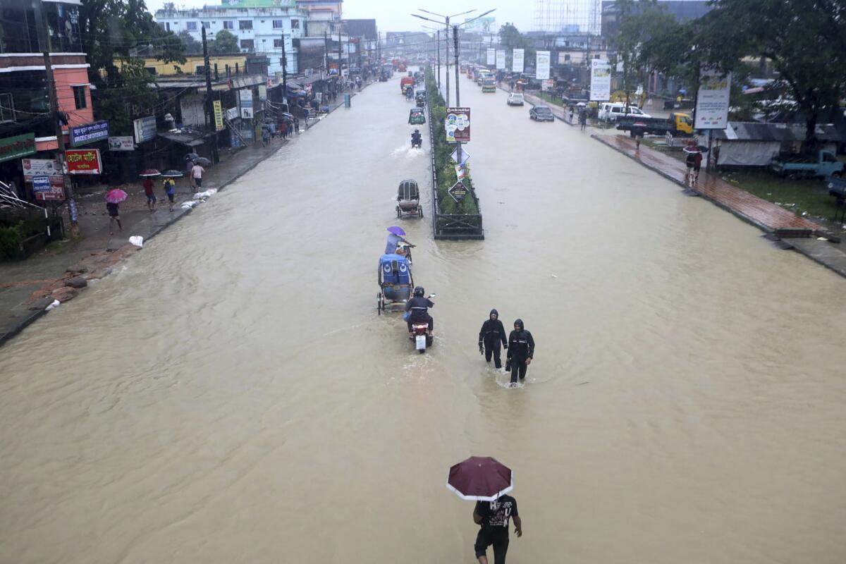 People wade through floodwaters.