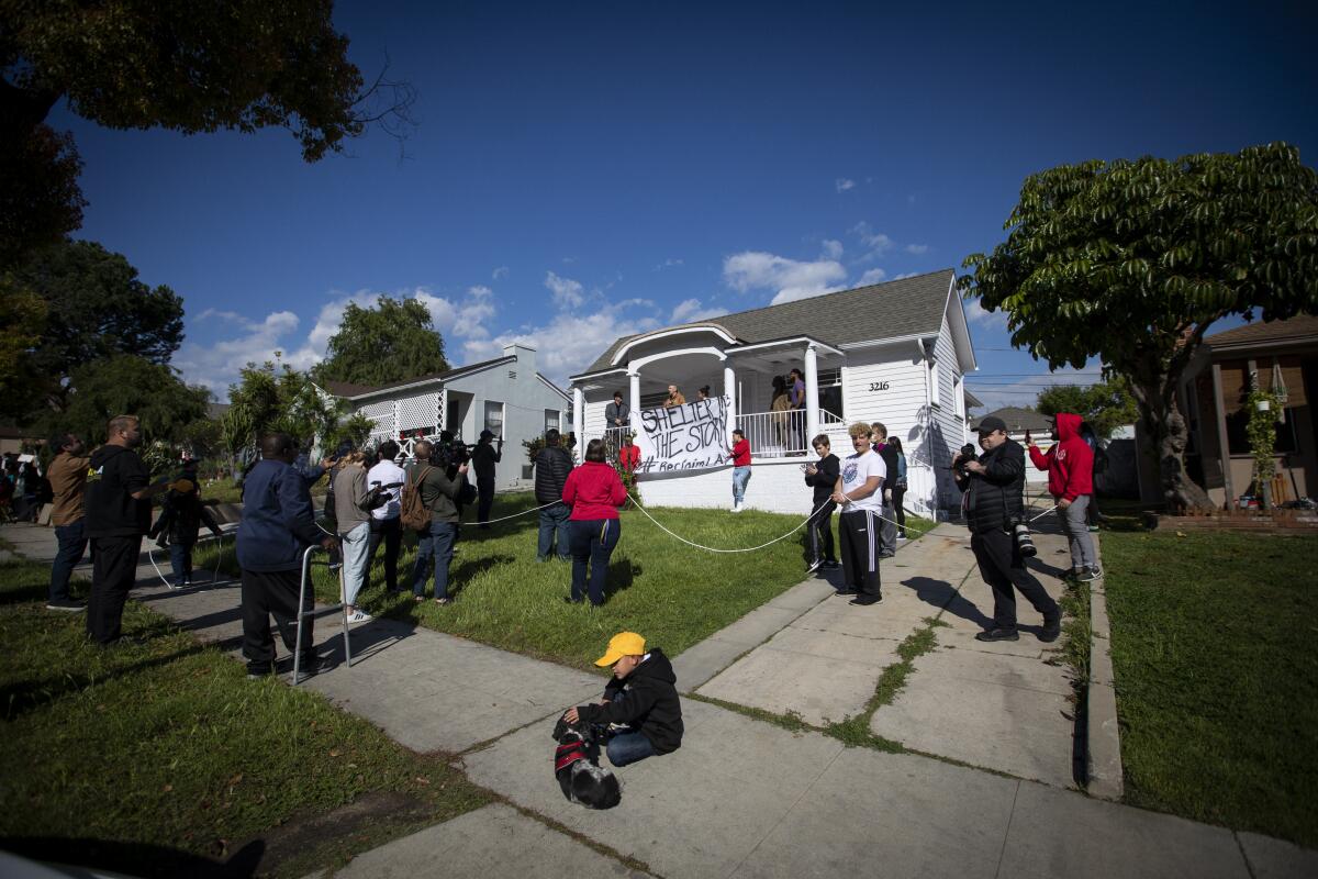 Supporters stood guard while a group of homeless and housing-insecure protesters took over several houses in El Sereno on Wednesday.