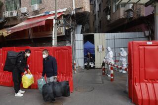 Migrant workers with their belongings leave a barricaded village after authorities' easing of COVID-19 curbs in Haizhu district in Guangzhou in south China's Guangdong province on Friday, Dec. 2, 2022. Local Chinese authorities on Saturday announced a further easing of COVID-19 curbs, with major cities such as Shenzhen and Beijing no longer requiring negative tests to take public transport. (Chinatopix Via AP)