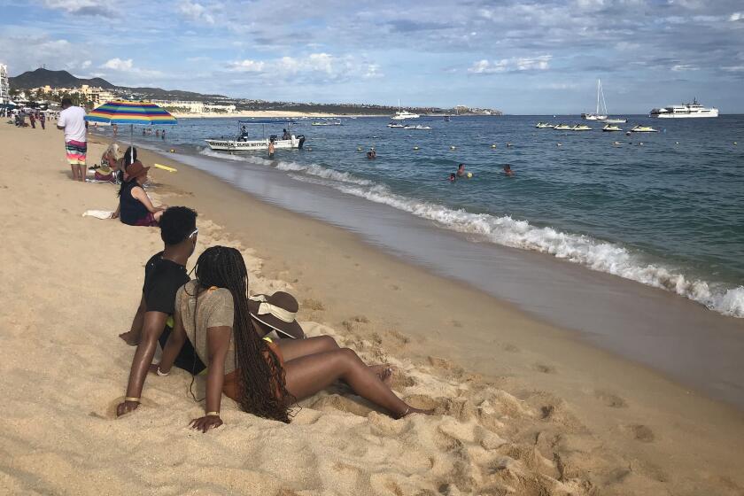 Brandon Harris, 24, and Kirsten Jackson, 24, traveled from Houston to spend a week in Los Cabos despite rising caseloads in both countries. "I definitely would rather be wearing a mask and looking at this than sitting at home," Jackson said.