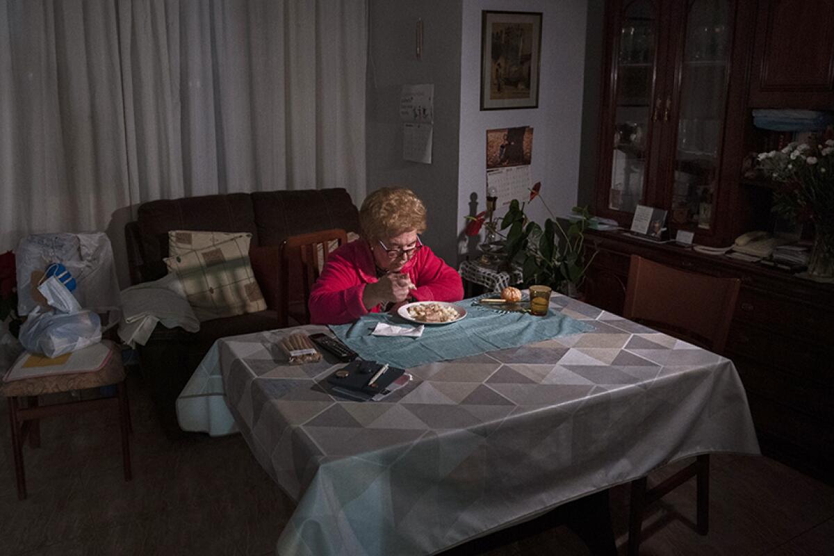 Rosa Otero, 83, eats Christmas Eve dinner alone at her home in Barcelona, Spain.
