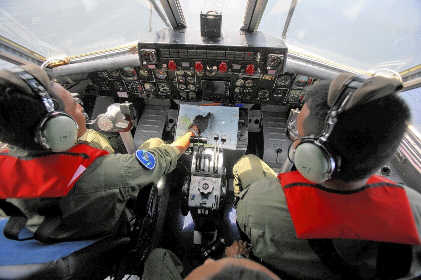 Indonesian navy pilots take part in the search for the missing Malaysia Airlines Boeing 777 near the Malacca Strait.