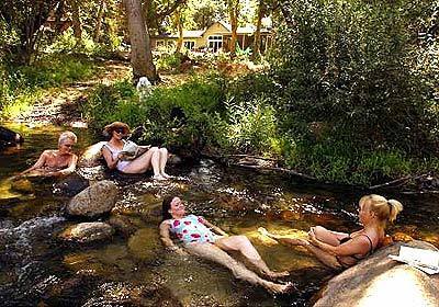 Behind her house in Three Rivers, Jenny Armit, with hat and glasses on, lounges in the clear waters of the Kaweah River with daughter Tallulah, center, and guests David Philp, left, and Hunter Drohojowska-Philp.