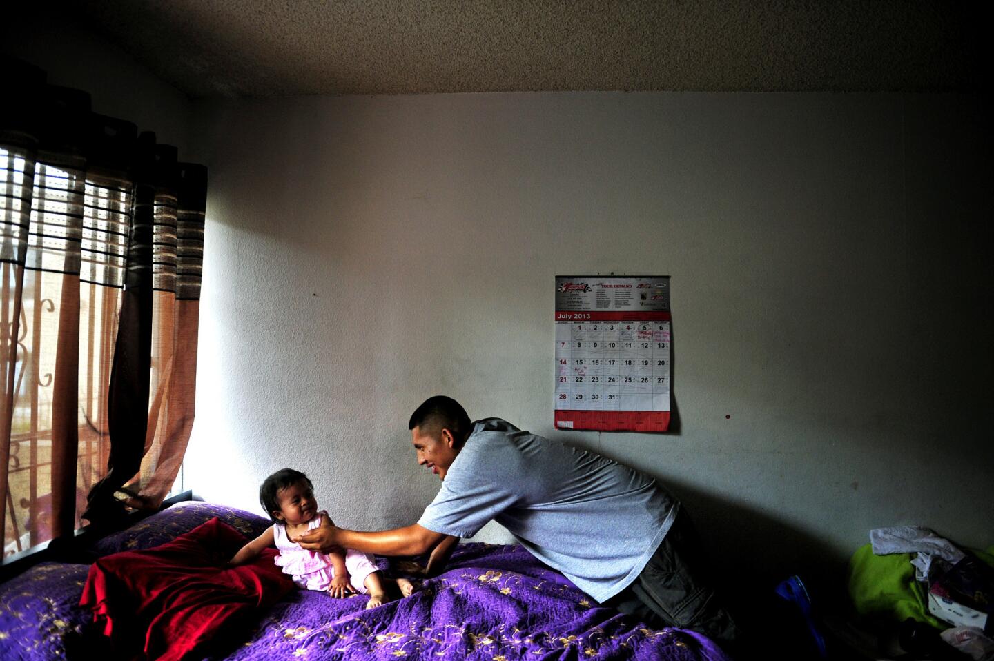 Frank Mariano, 16, a participant in the L.A. Fathers Program at Children's Hospital Los Angeles, jokes around with his 1-year-old daughter, Anabell, in their Koreatown home. In about a year, nearly 250 teenage fathers have gone through the 10-week program.