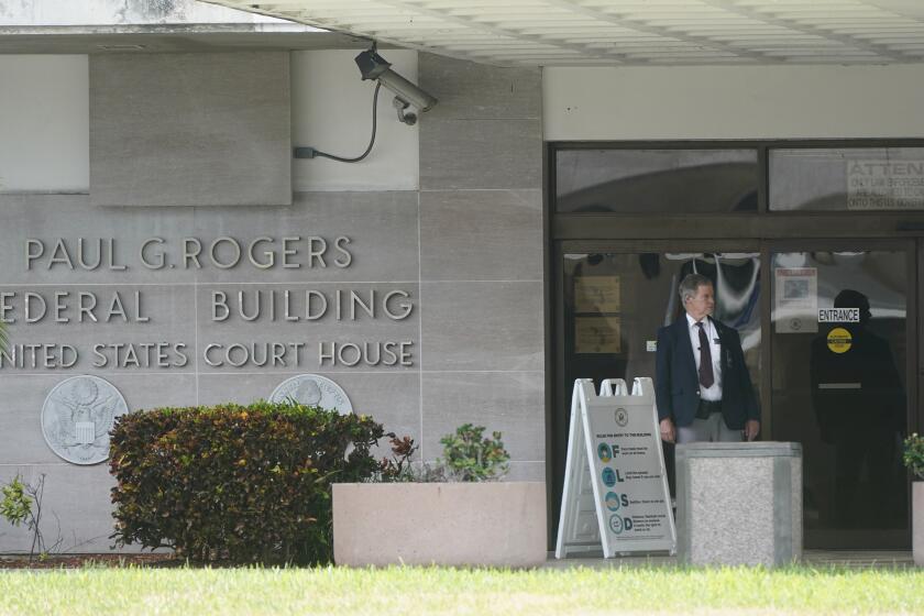 A security guard stands outside the Paul G. Rogers Federal Building and U.S. Courthouse, Thursday, Sept. 1, 2022, in West Palm Beach, Fla. A federal judge heard arguments Thursday on whether to appoint an outside legal expert to review government records seized by the FBI last month in a search of former President Donald Trump's Florida home. There was no immediate ruling. (AP Photo/Wilfredo Lee)