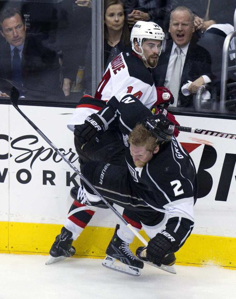 Kings defenseman Matt Greene, front, loses his helmet after being hit by New Jersey forward Adam Henrique during the third period in Game 3 of the Stanley Cup Final at Staples Center.