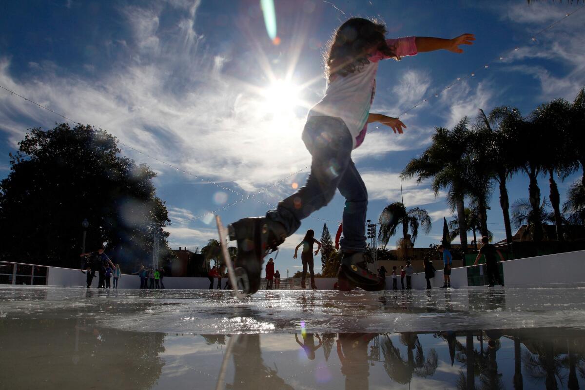 Children enjoy ice skating on a sunny afternoon at the opening day of the ice ring in Liberty Station Friday.