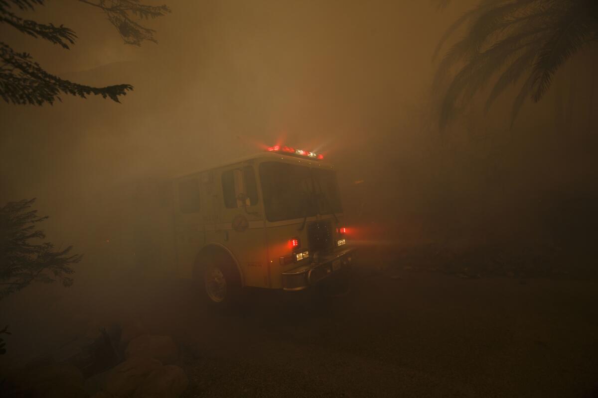 A fire truck moves into position to battle fires burning near homes on East Mountain Drive in Montecito.
