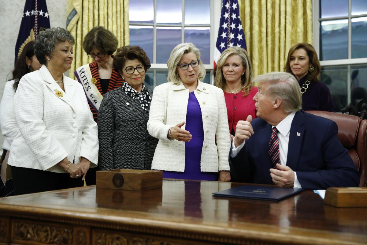 FILE - In this Nov. 25, 2019, file photo, Rep. Liz Cheney, R-Wyo., center, speaks with President Donald Trump during a bill signing ceremony for the Women's Suffrage Centennial Commemorative Coin Act in the Oval Office of the White House in Washington. Trump and his supporters are intensifying efforts to shame members of the party who are seen as disloyal to the former president and his false claims that last year’s election was stolen from him.(AP Photo/Patrick Semansky, File)