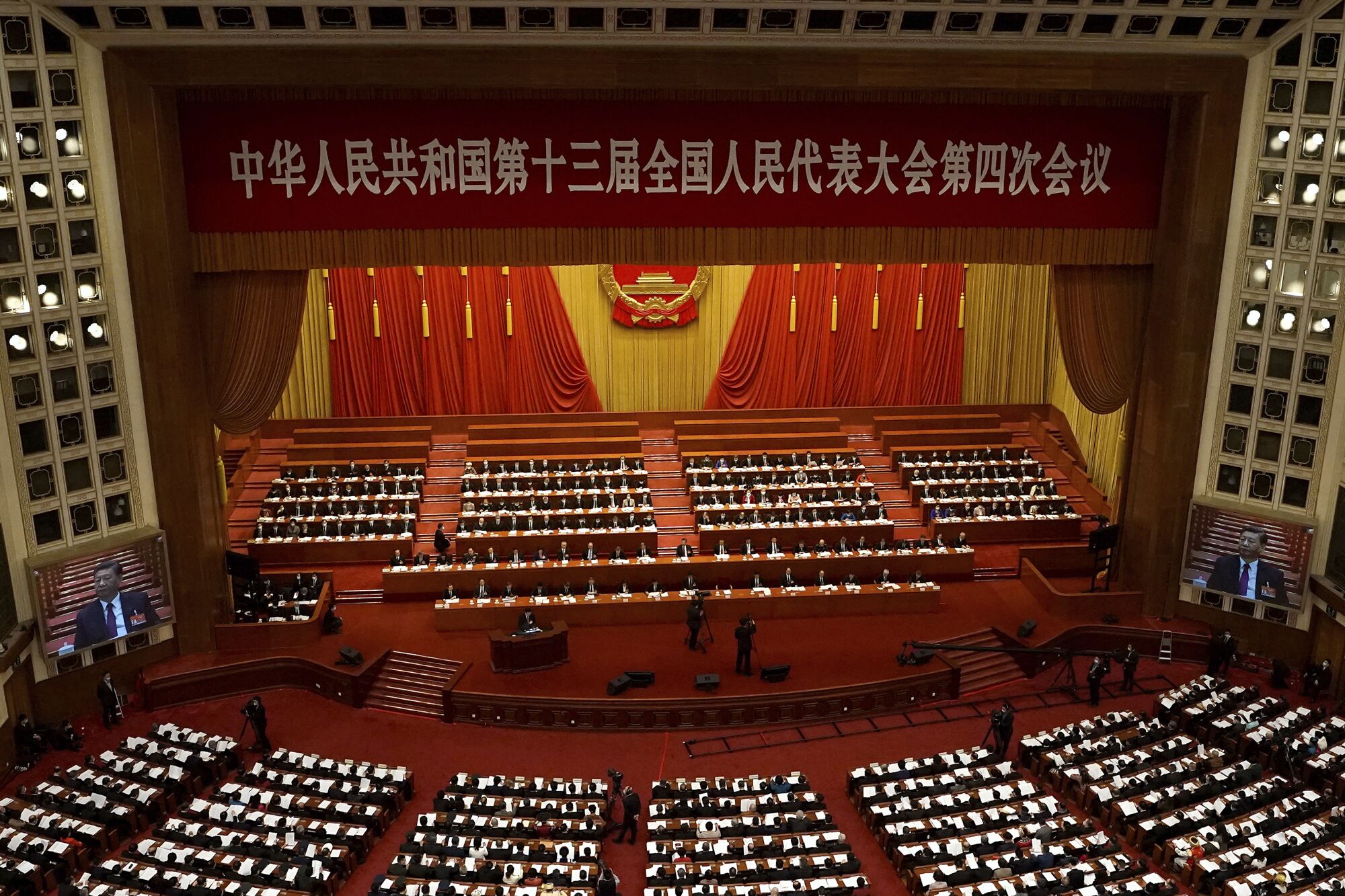 Delegates gather for a session of the Chinese legislature in a red and gold chamber