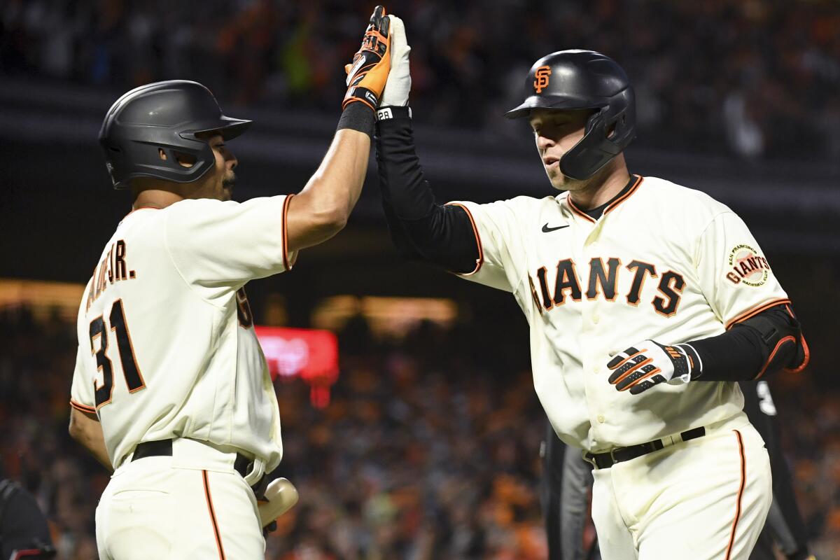 San Francisco’s Buster Posey celebrates with LaMonte Wade Jr. after hitting a two-run home run.
